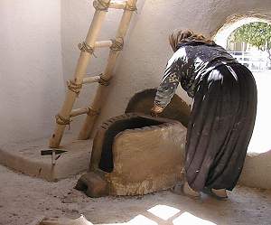 Figure 3: Hatice Yaşlı building the oven inside the reconstruction house