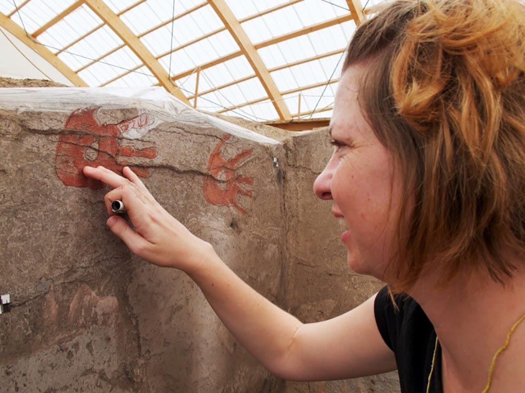 Photo of Kathryn tracing Neolithic handprints. Photo by Jason Quinlan